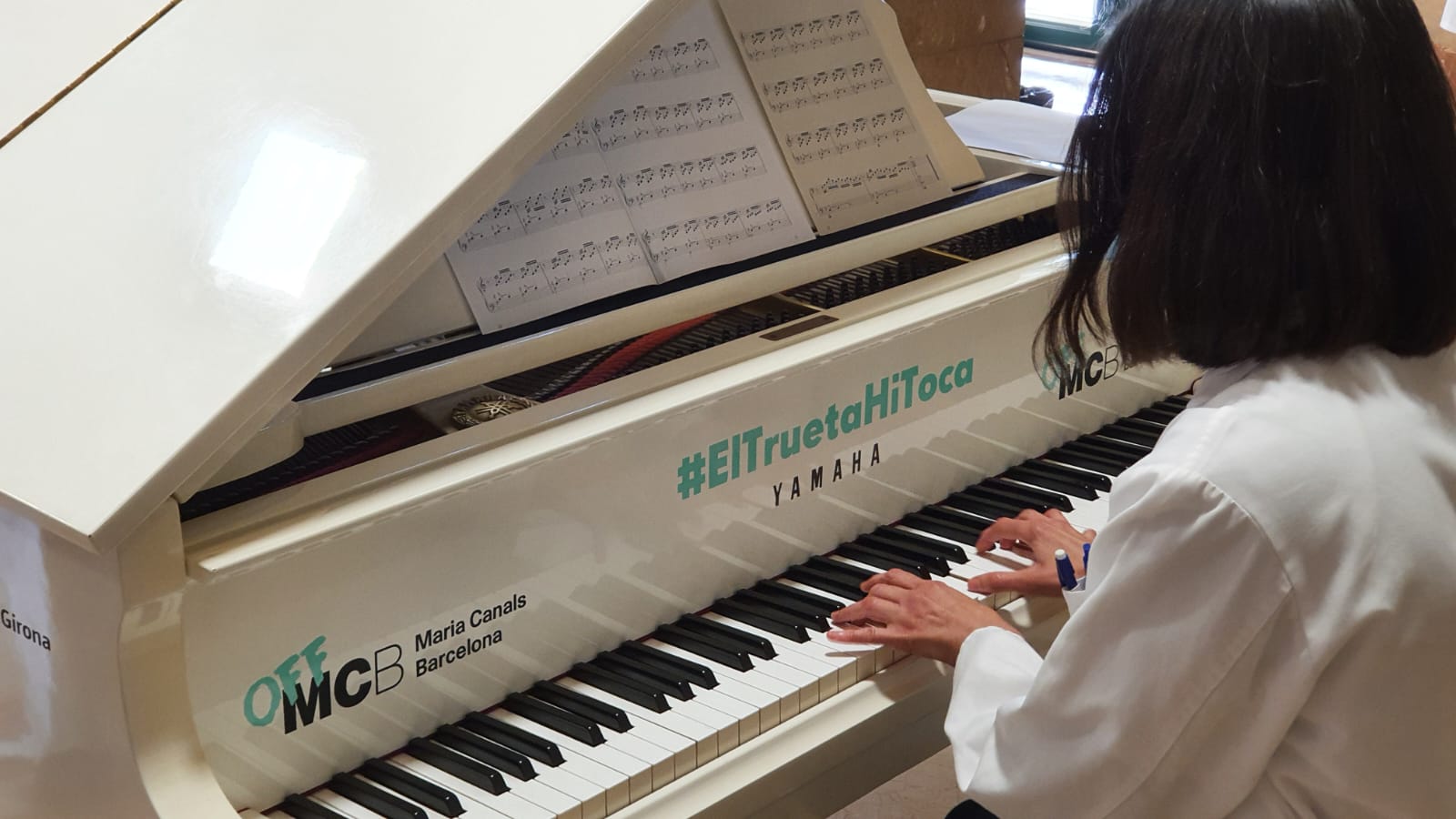Una professional de l'Hospital Trueta toca el piano que es troba instal·lat al vestíbul del centre