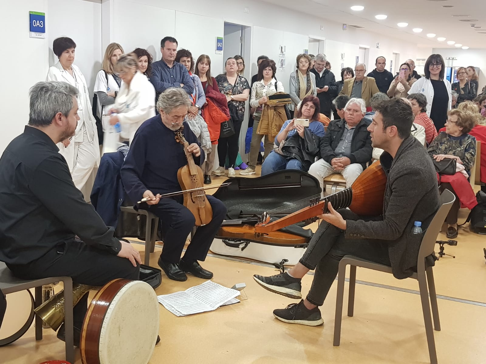 Els tres músics tocant, amb usuaris i professionals escoltant