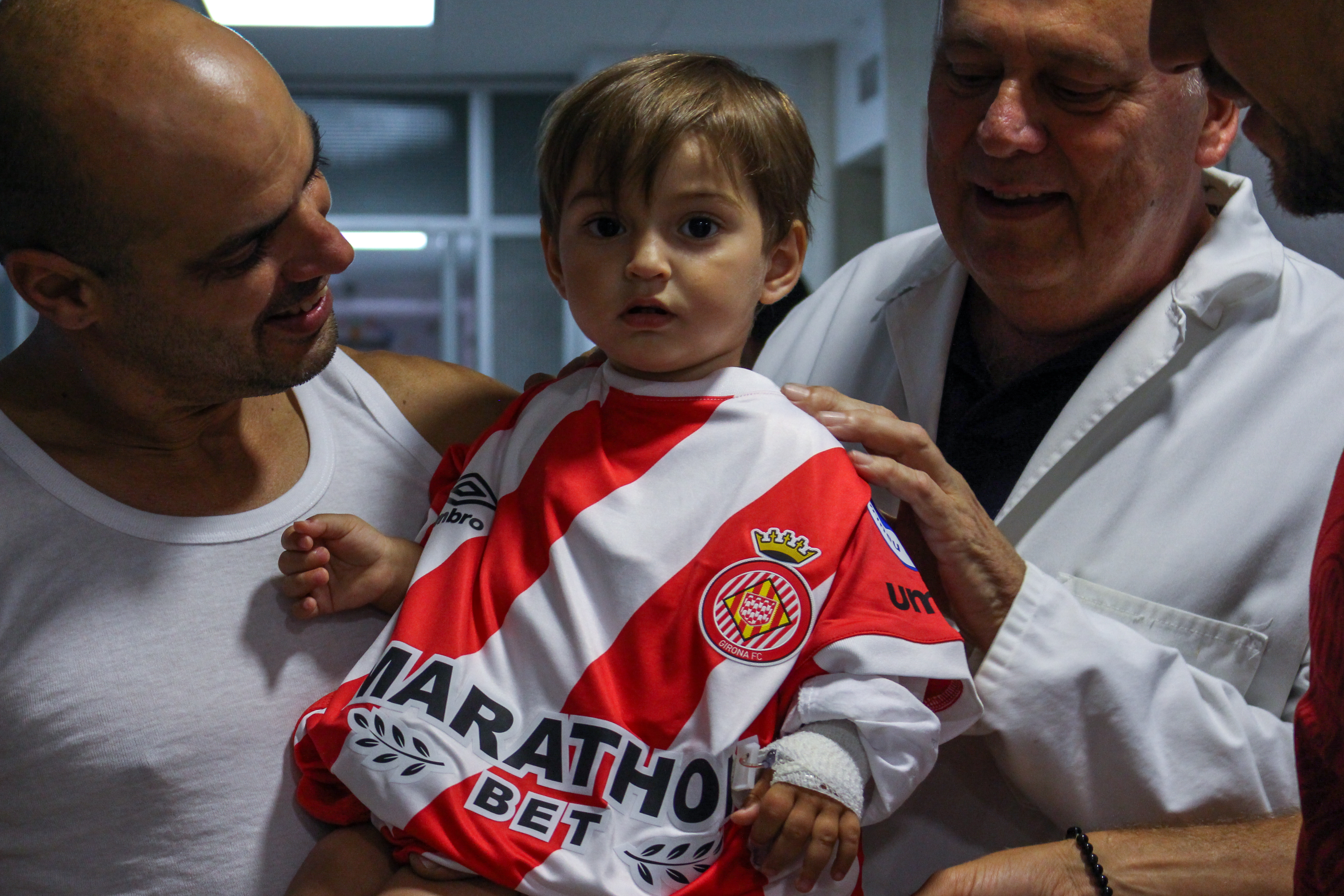 un infant ingressat porta la samarreta del Girona de fútbol reconvertida en bata d'hospital