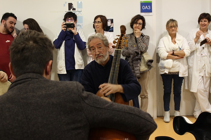 Jordi Savall amb professionals sanitaris al fons.