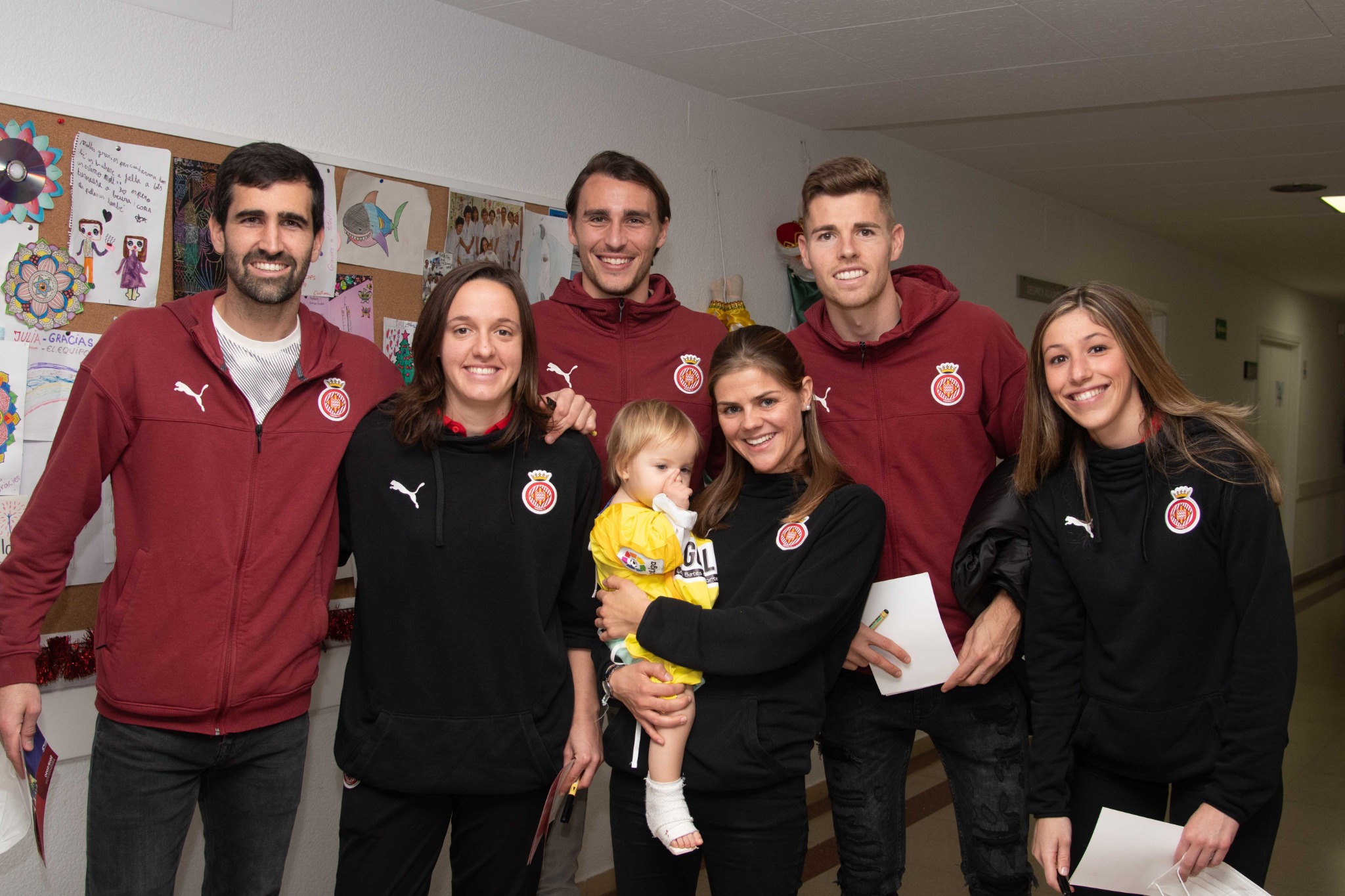 Els jugadors i jugadores del Girona amb la Cora, de 2 anys, a coll de la Júlia Vilardell