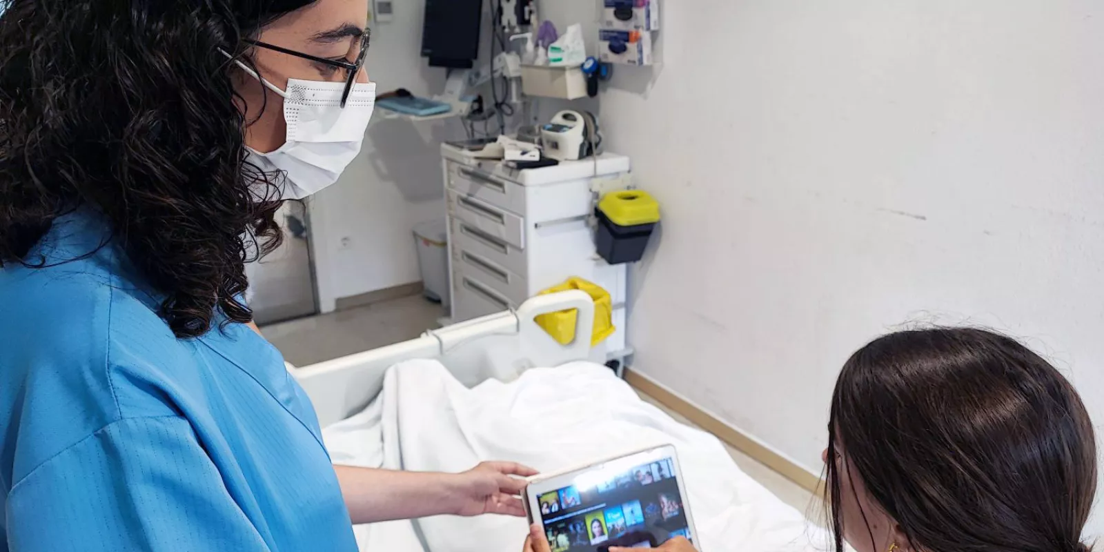 La infermera Laura Cano facilita la tauleta per realitzar l'estudi sobre l'efecte de la distracció audiovisual i musical en l'ansietat de les persones postoperades.