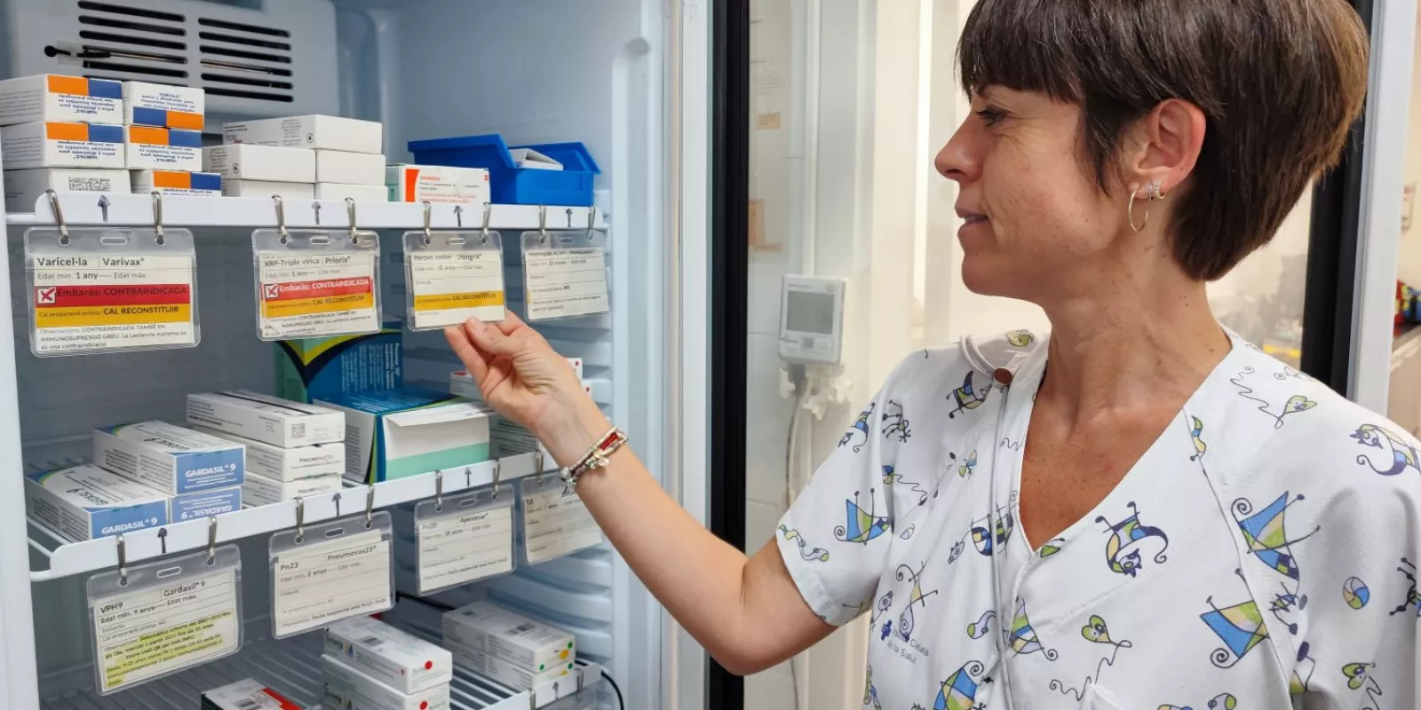 Professional de l'ICS Girona revisa les etiquetes identificatives d'una de les neveres on s'emmagatzemen les vacunes.