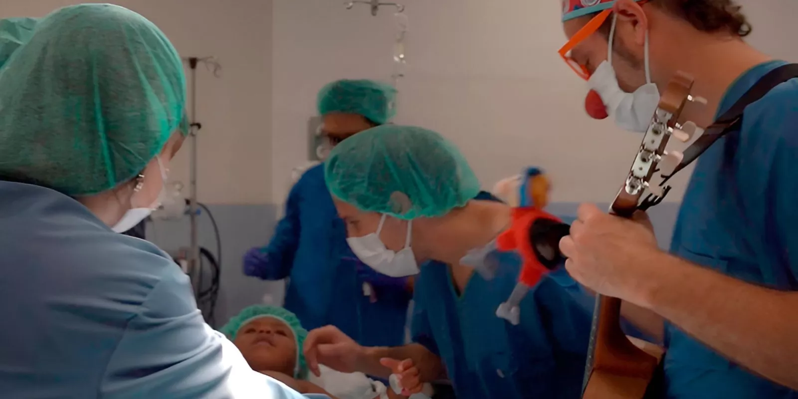 Un infant ja a quiròfan durant la inducció a l'anestèsia i acompanyat per un familiar i un component de Pallapupas. 