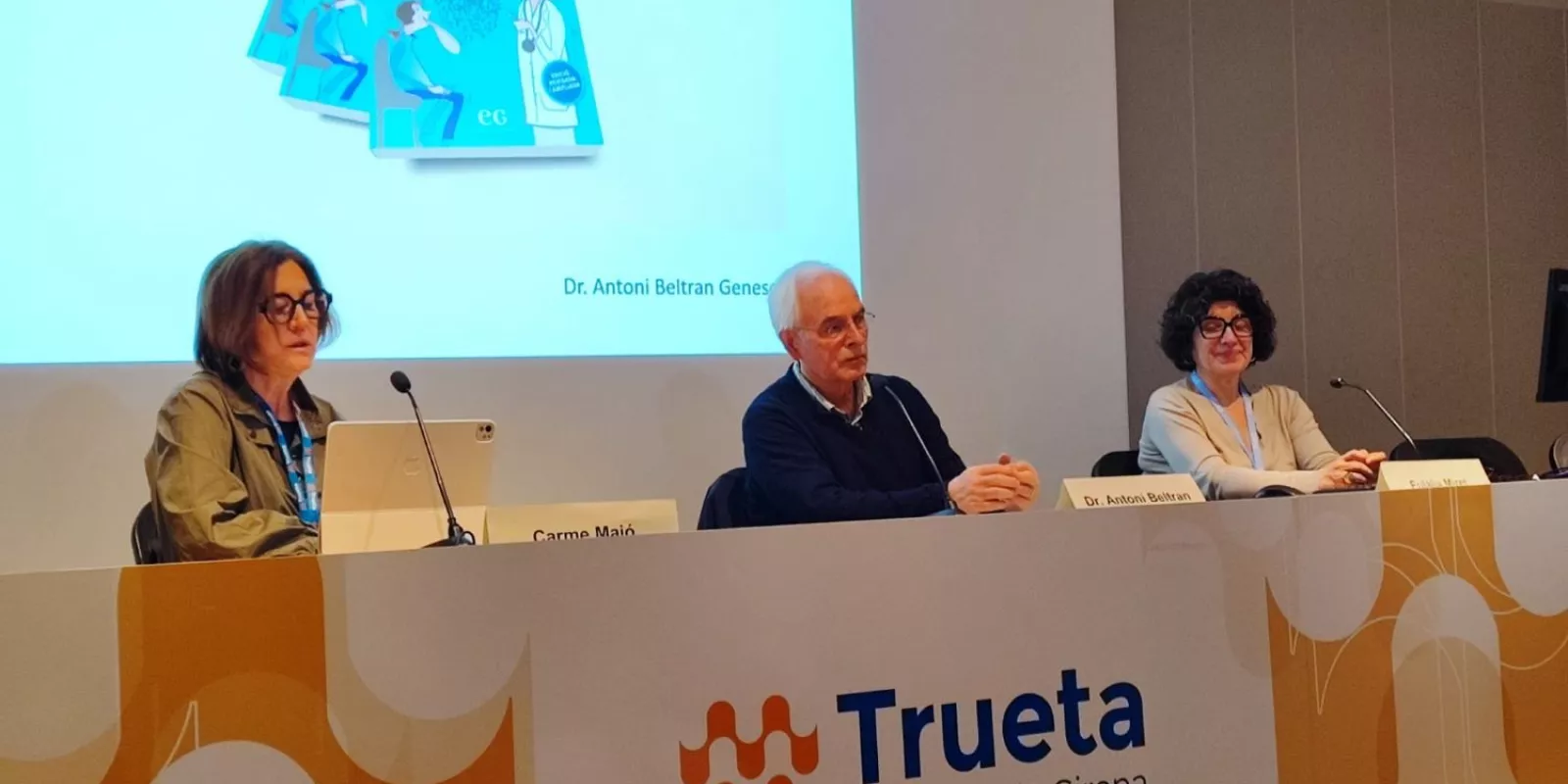 El Dr. Antoni Beltran presenta el seu llibre al Trueta acompanyat per les referents lingüístiques Carme Majó i Eulàlia Miret