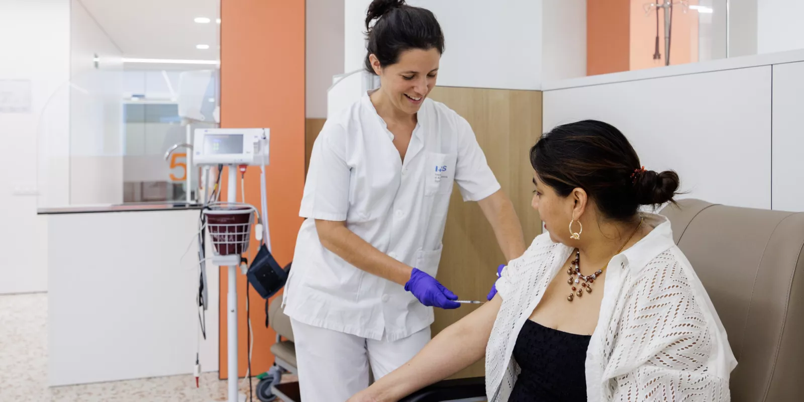 Una professional d'infermeria atén una usuària de l'Hospital de Dia de l'IAS.