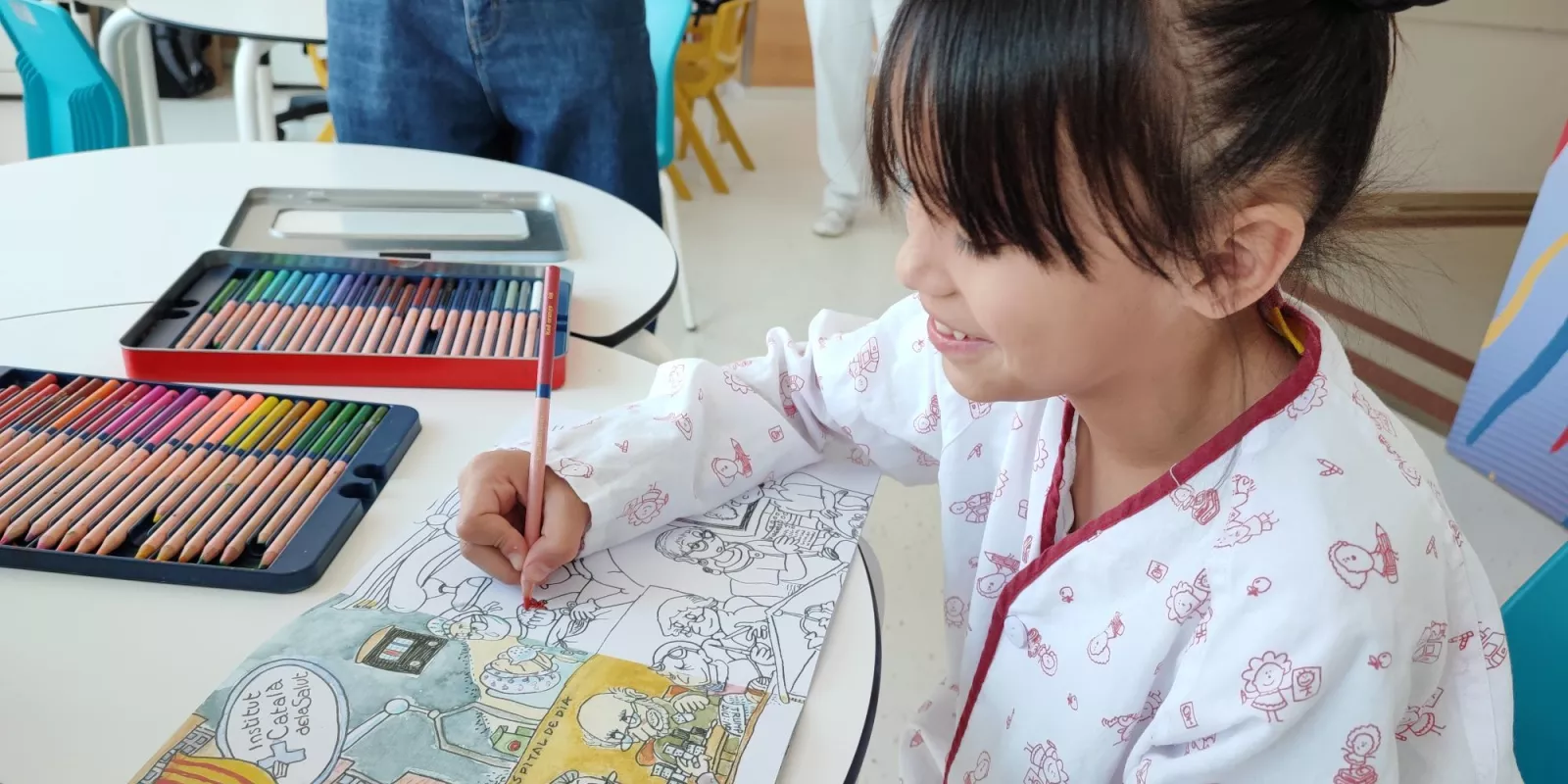 Una pacient ingressada a l'àrea de pediatria del Trueta amb el quadern per acolorir de Pilarín Bayés dedicat al Trueta
