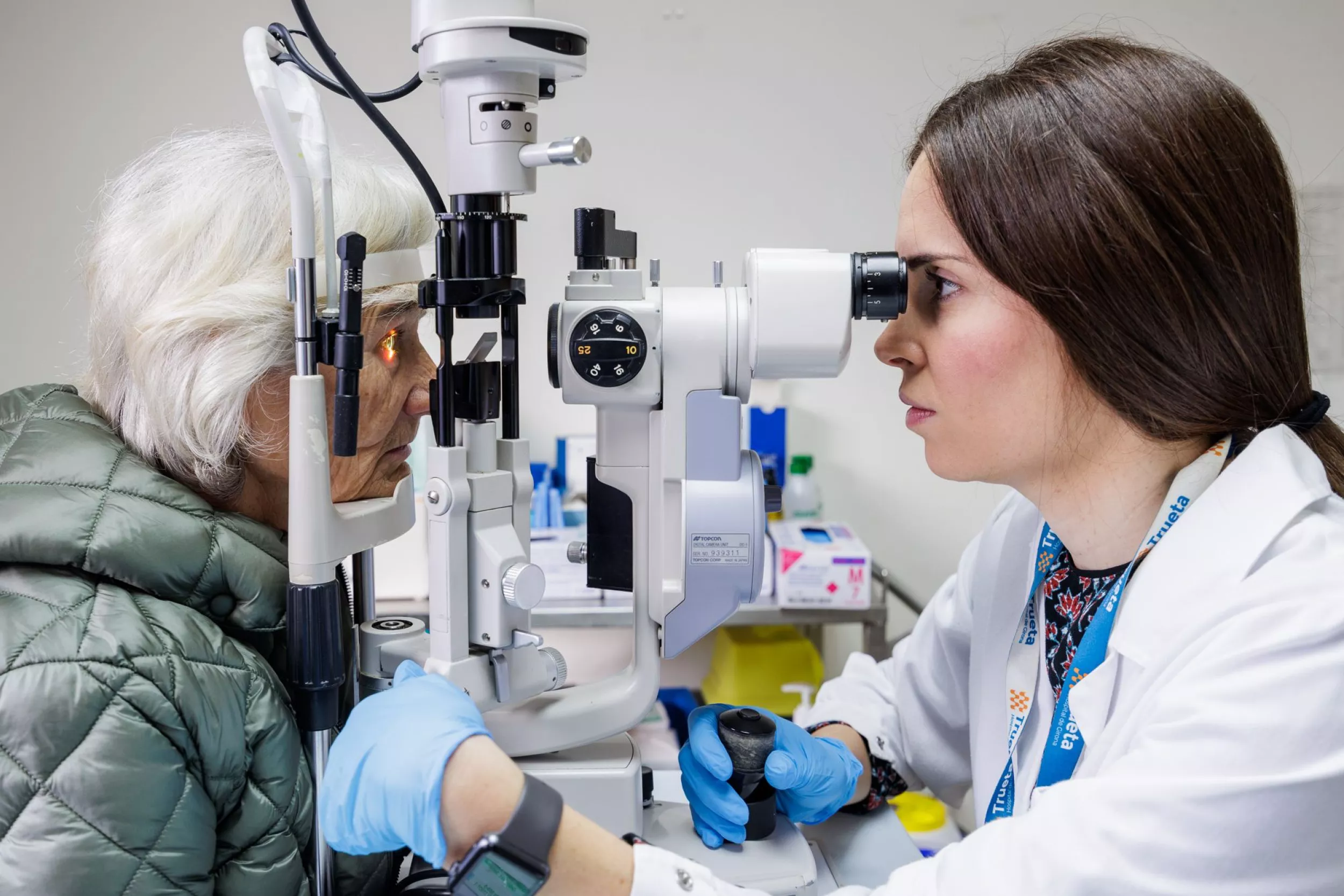 Una metgessa mirant amb un aparell els ulls duna pacient