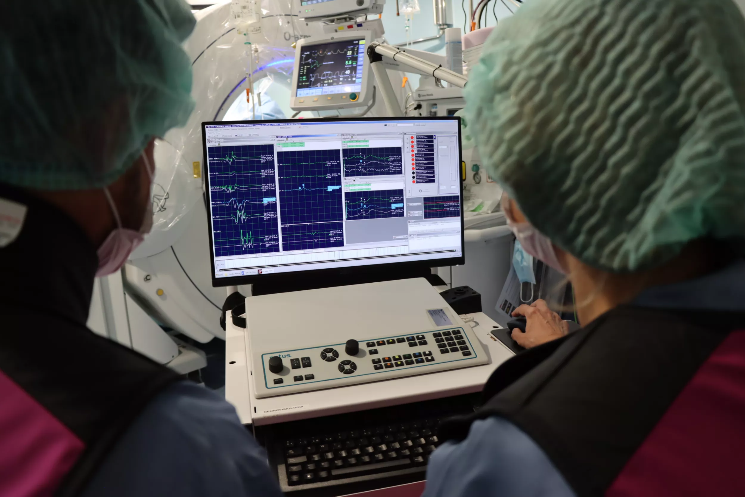 Professionals de neurofisiologia controlant un monitor a quiròfan.