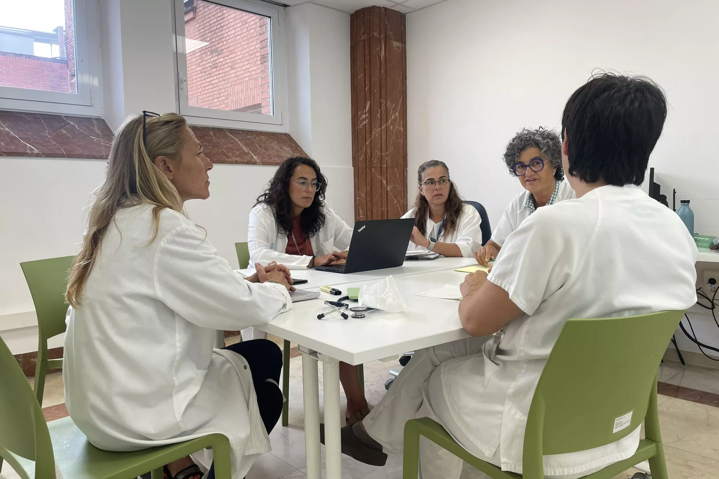 Cinc metges reunits en una taula