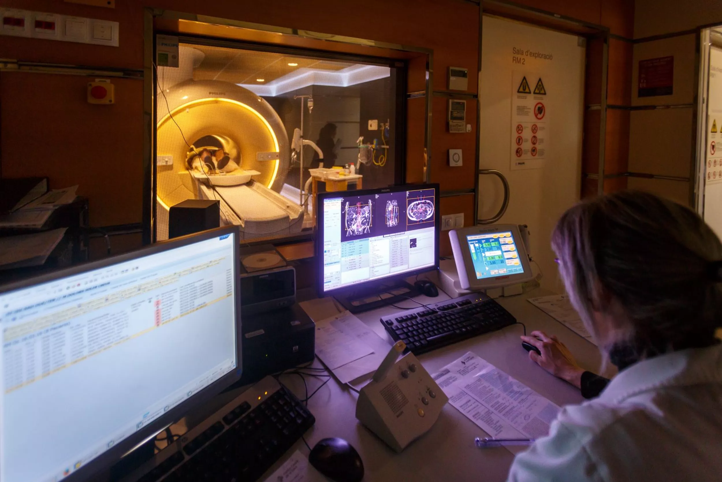 Metge fent un radiodiagnòstic a un pacient. El pacient està dins de la màquina