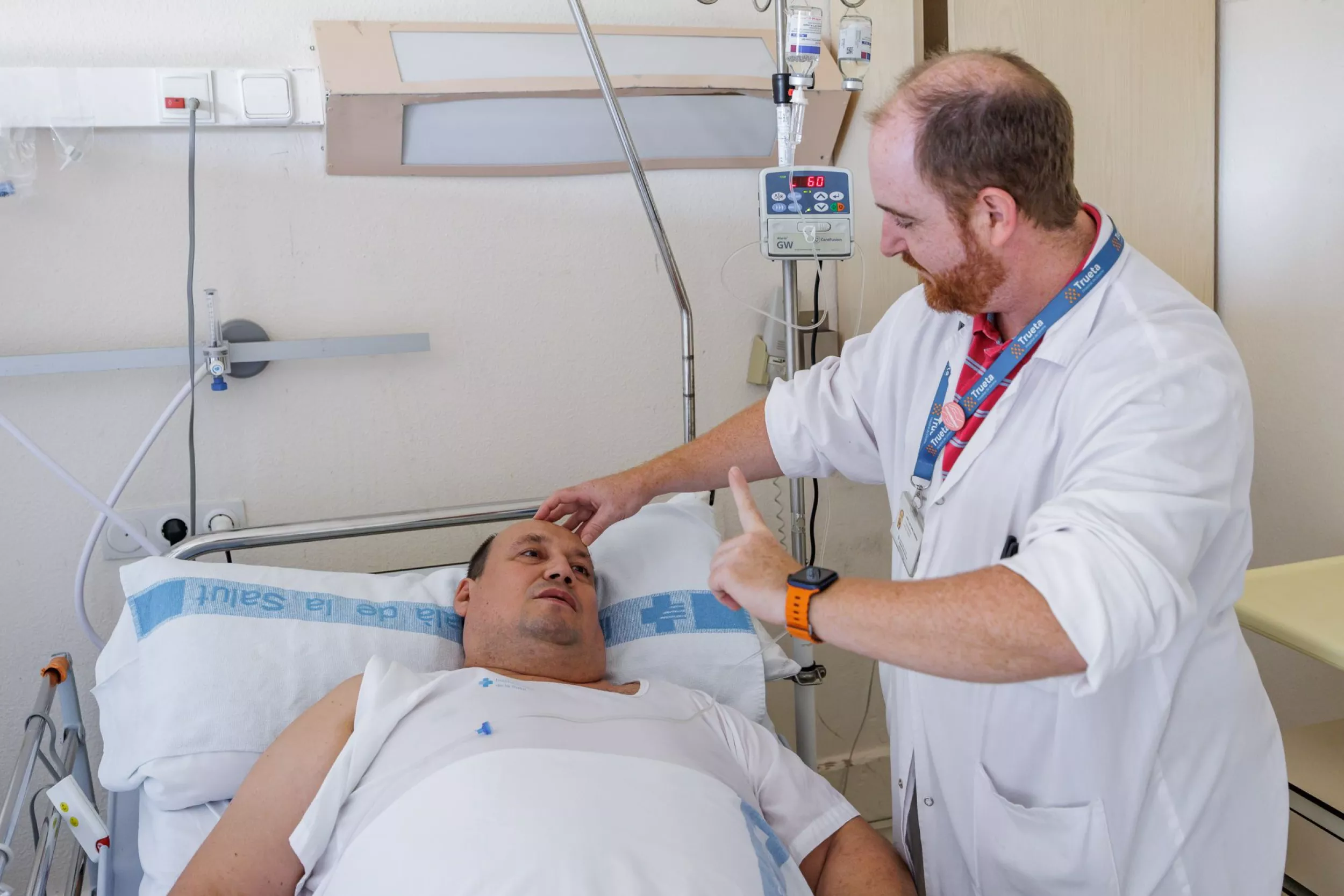 Metge comprovant els reflexos a un pacient que es troba a la cama