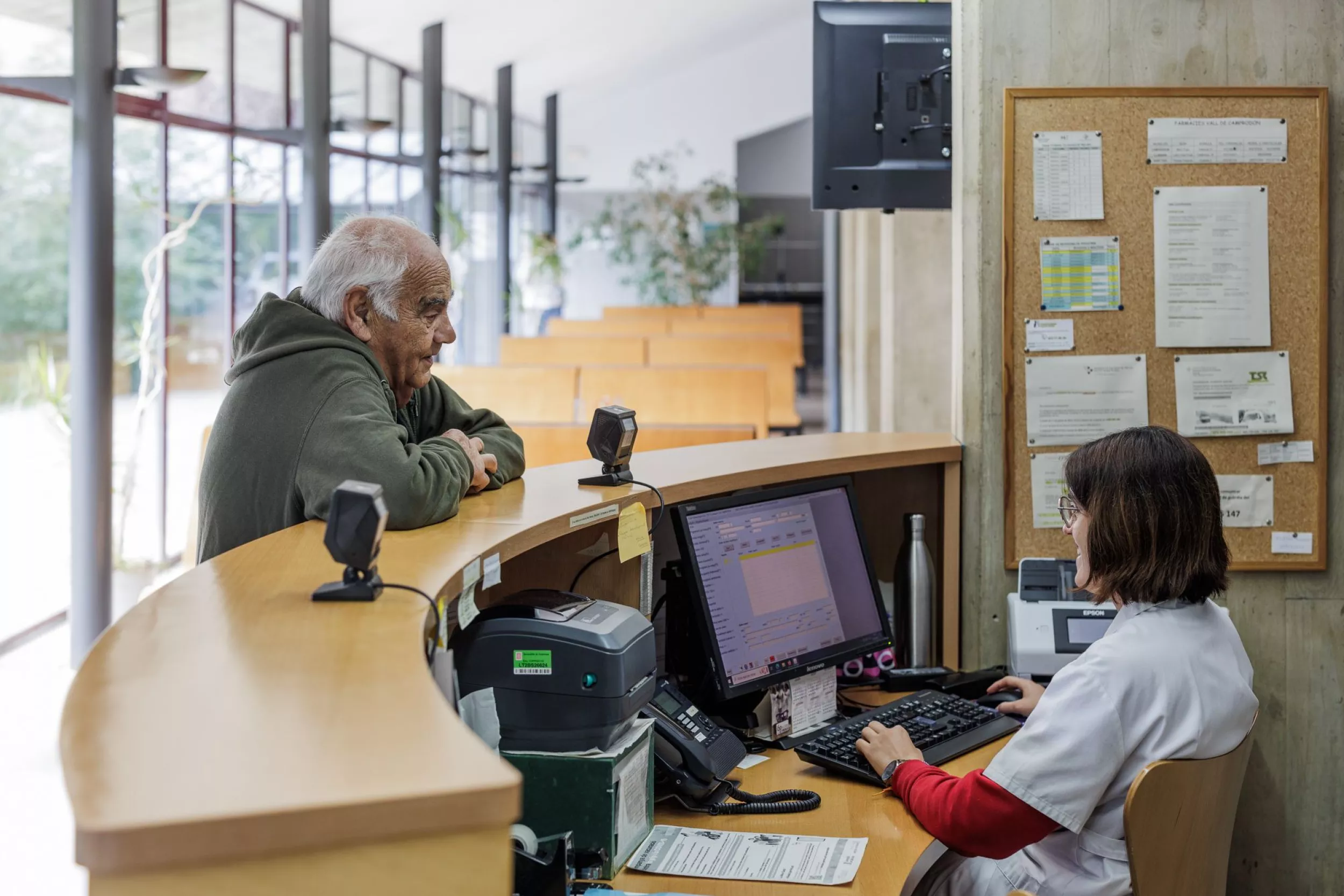 Taulell d'un CAP, administrativa atenent una persona