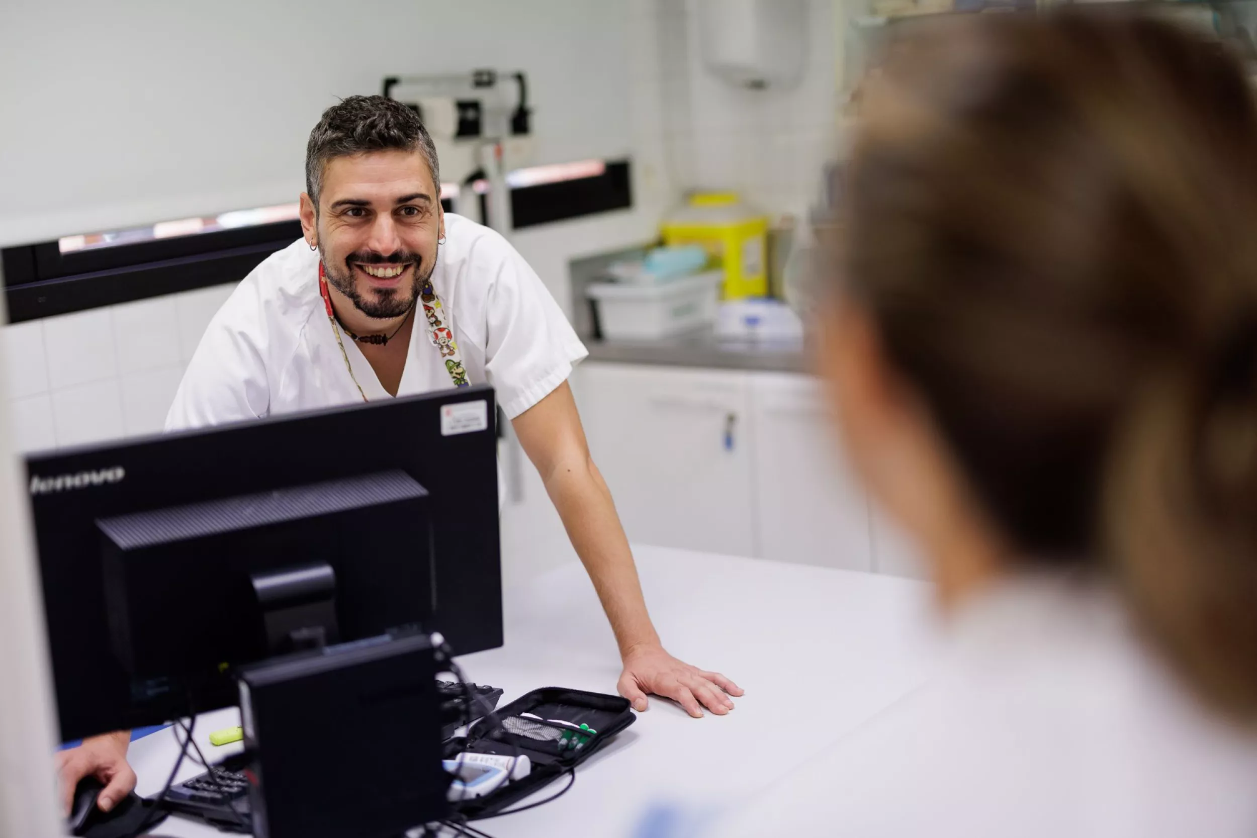 Enfermero sonriente atendiendo a una paciente en una consulta médica