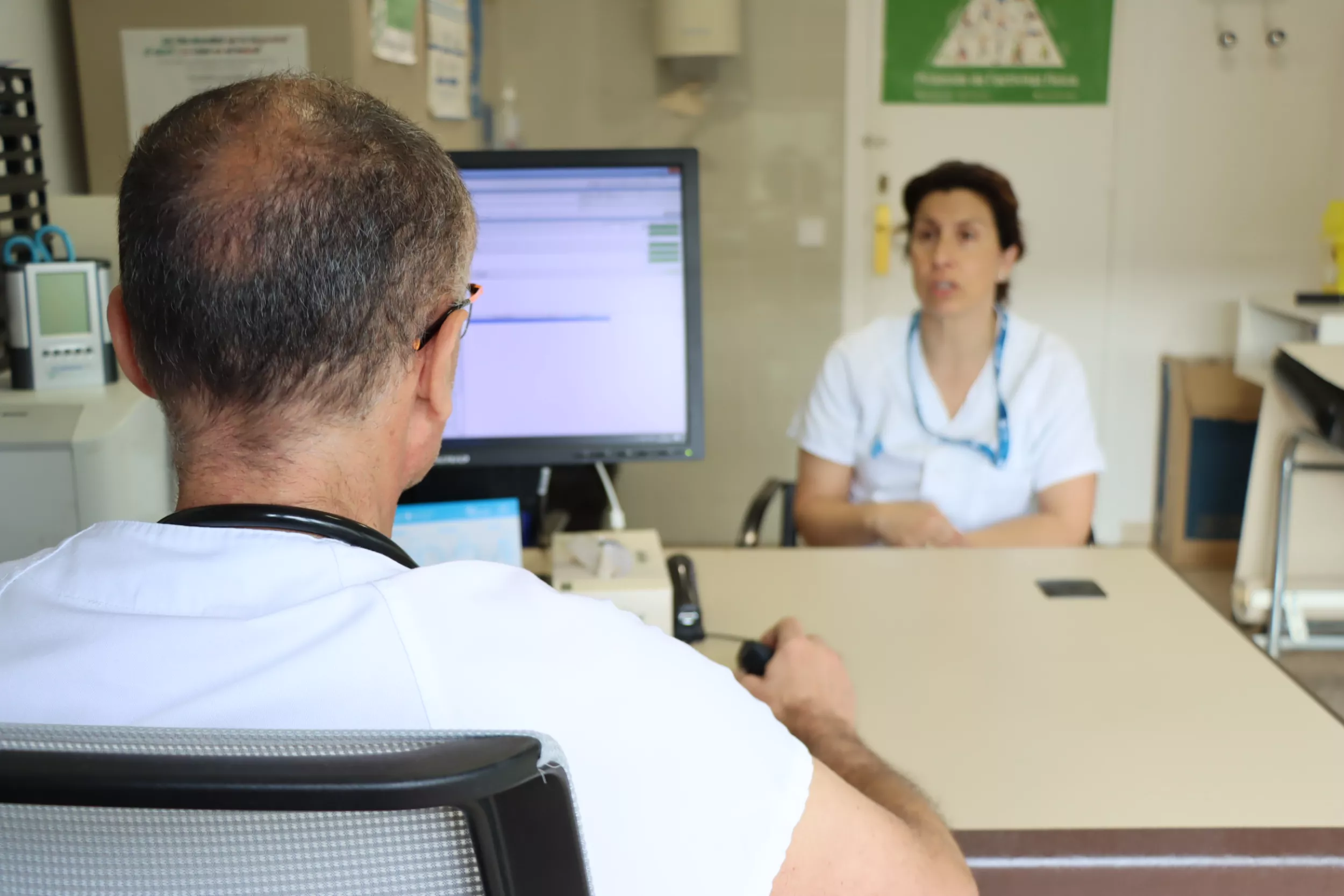 Metge laboral parlant amb un treballador a la consulta