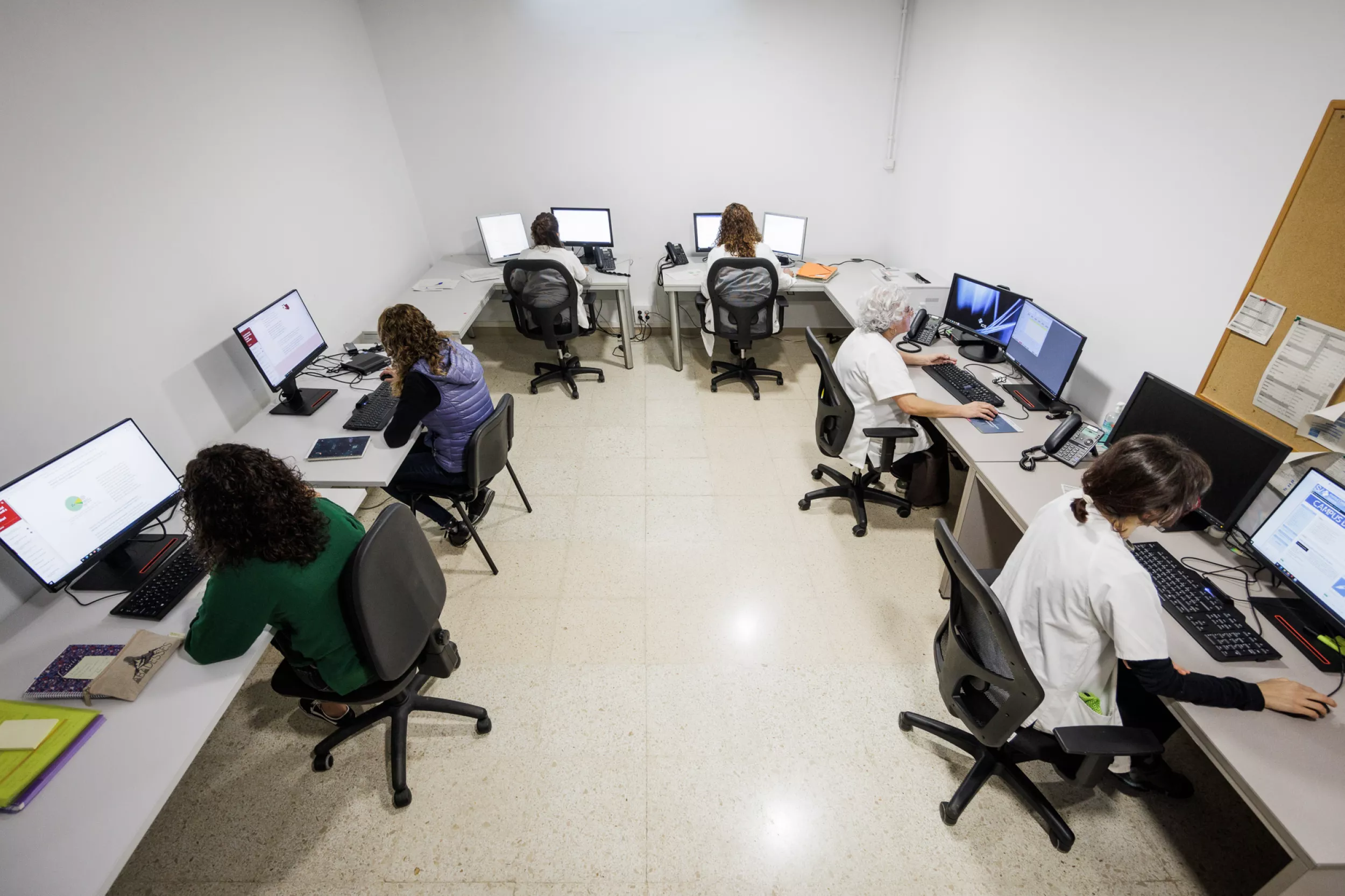 Oficina amb persones que treballen amb els seus ordinadors