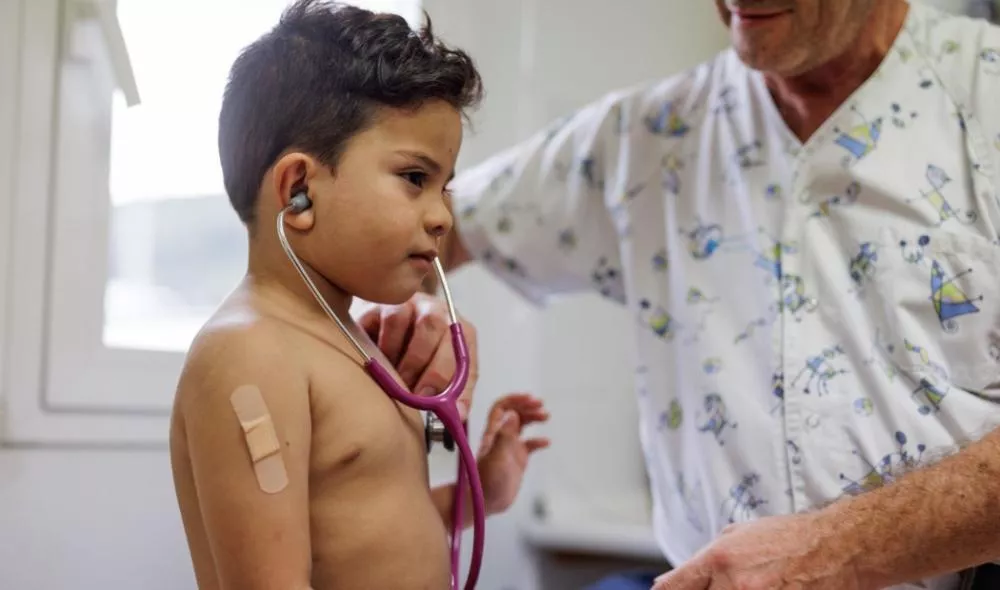 Médicos auscultando a un niño