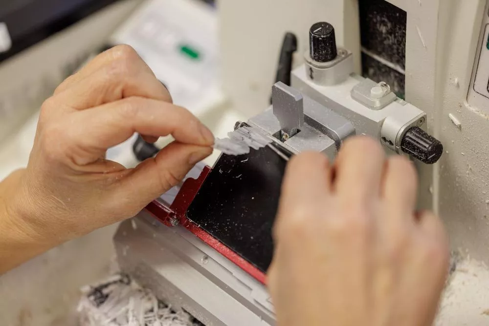 Dos manos de un trabajador manipulando una máquina