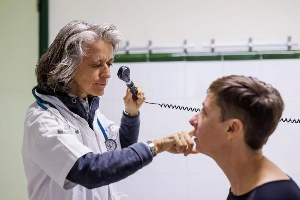 Médico con un utensilio en la mano apunto de observar el ojo del paciente
