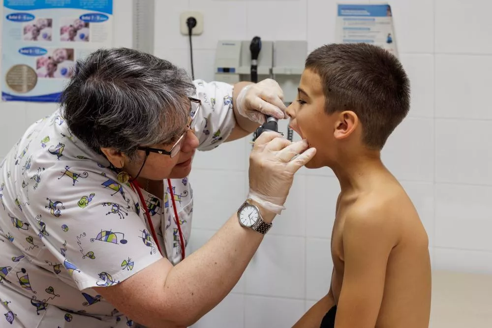 Médico inspeccionando la boca de un niño