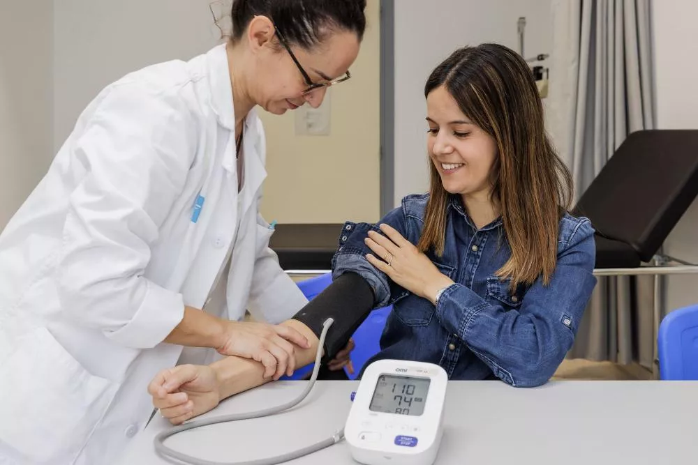 Médico tomando la tensión a una paciente