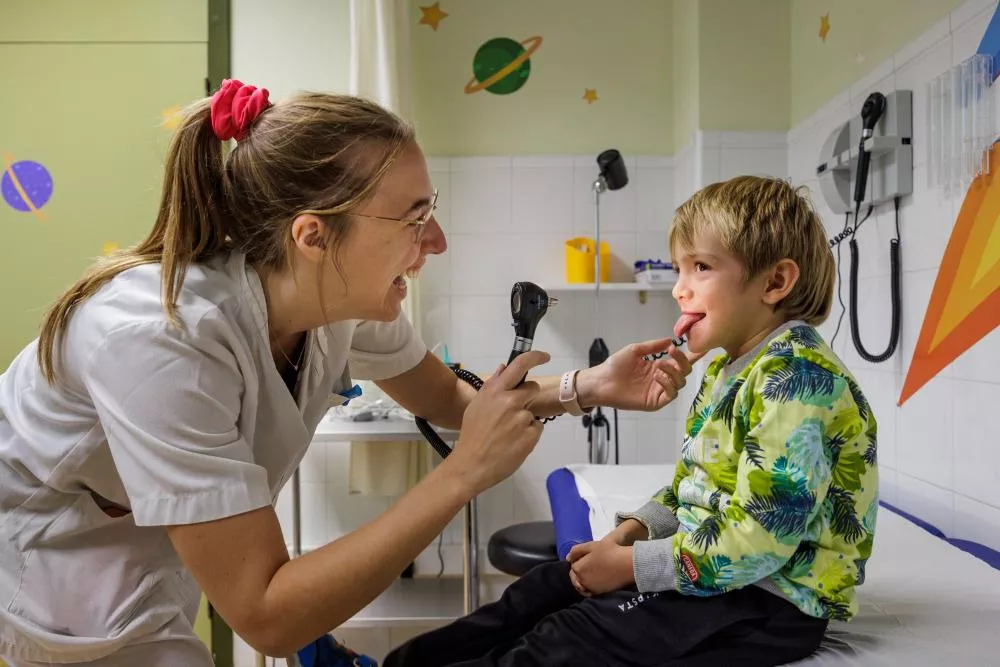 Médico inspeccionando la boca de un niño