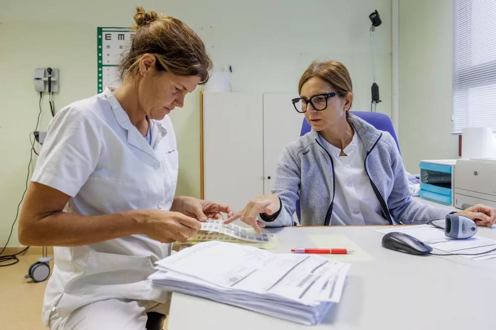 Dos trabajadoras del CAP hablando sobre unos documentos