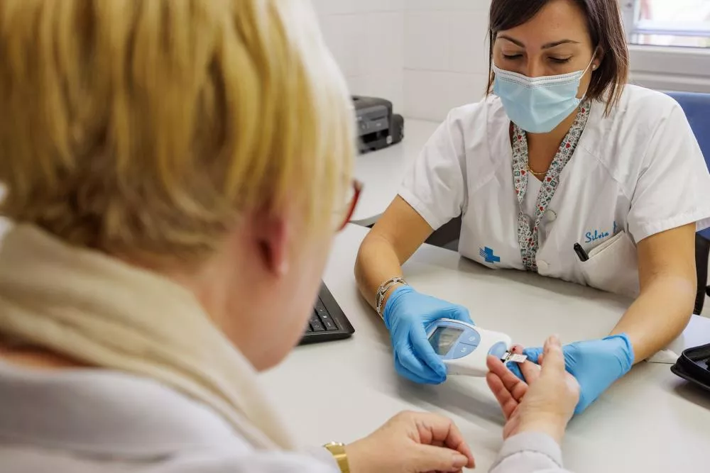 Enfermera midiendo el azúcar de una paciente