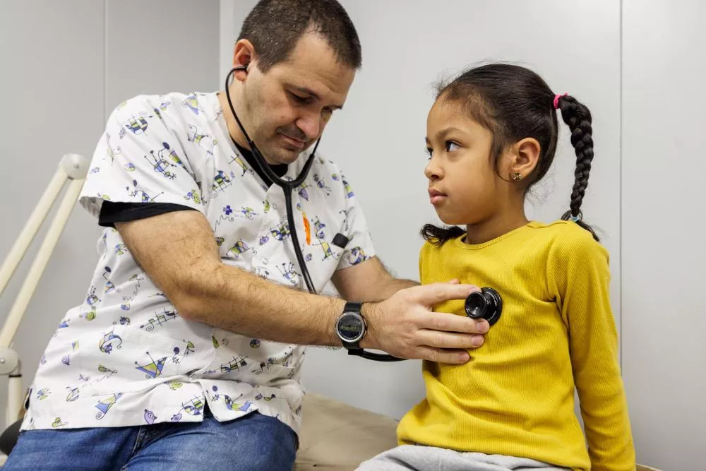 Médico auscultando a una niña
