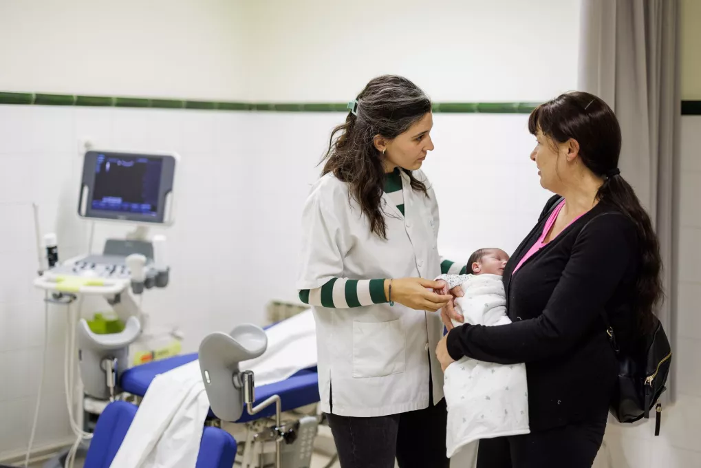 Médico hablando con una mujer con su bebe