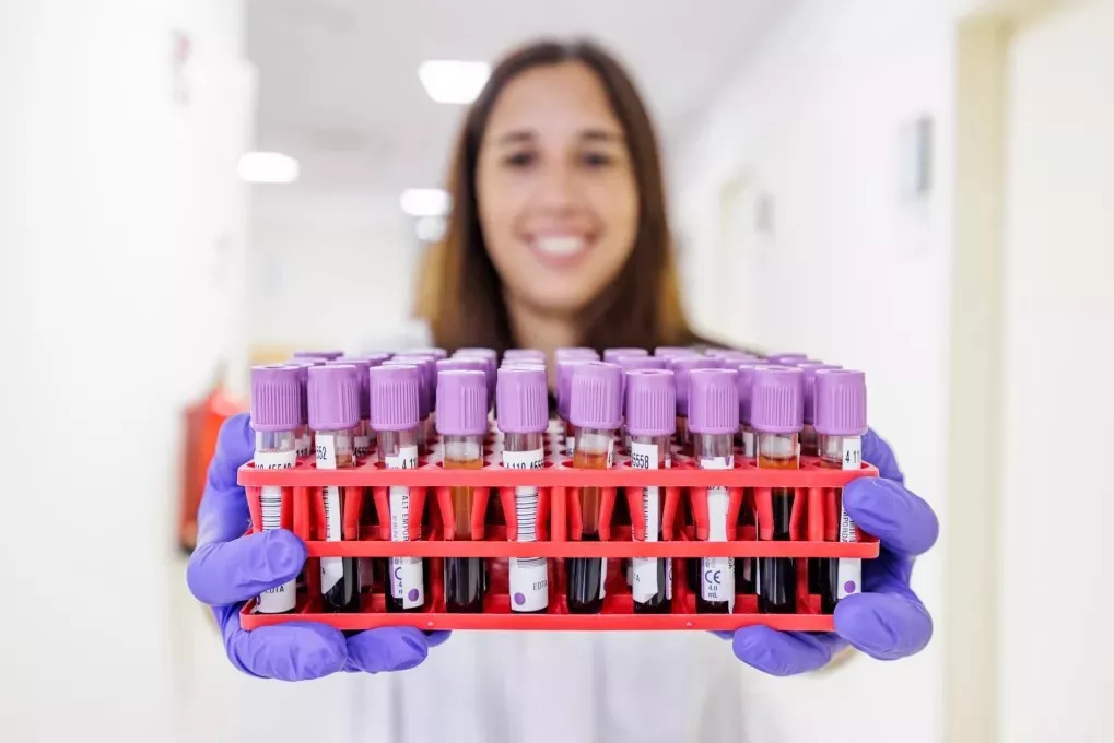 Una professional mostrando una caja de muestras del laboratorio. 
