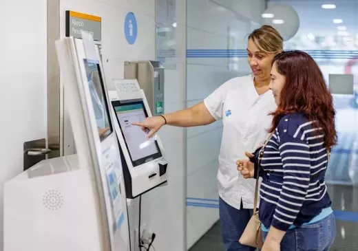 Una administrativa ensenyant a fer servir un TESEO a una usuària.