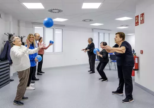 Pacientes de edad avanzada haciendo un juego con pelotas. 