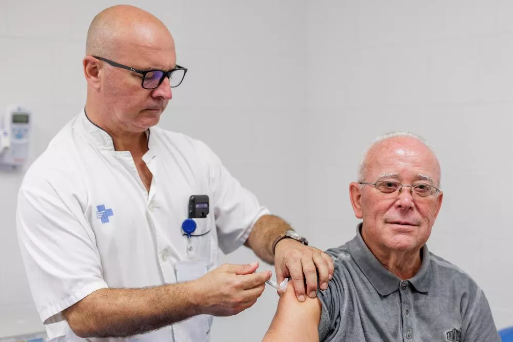 Un infermer vacunant un pacient