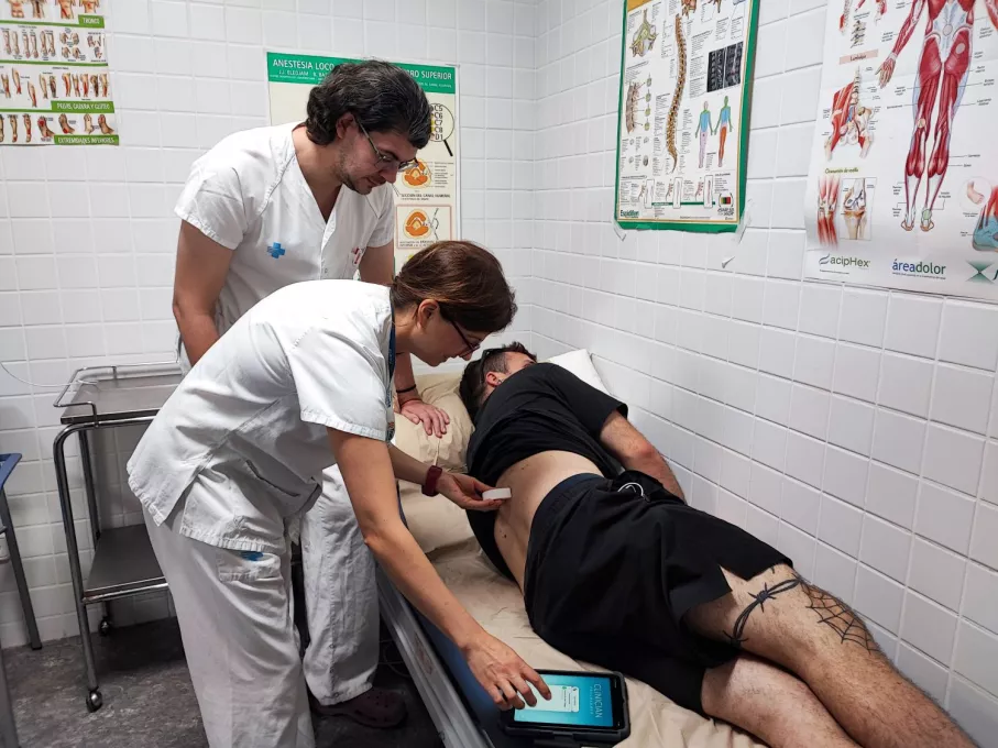 Professionals de la Unitat del Dolor del Trueta atenen la visita d'un pacient per a revisar el funcionament d'un neuroestimulador 