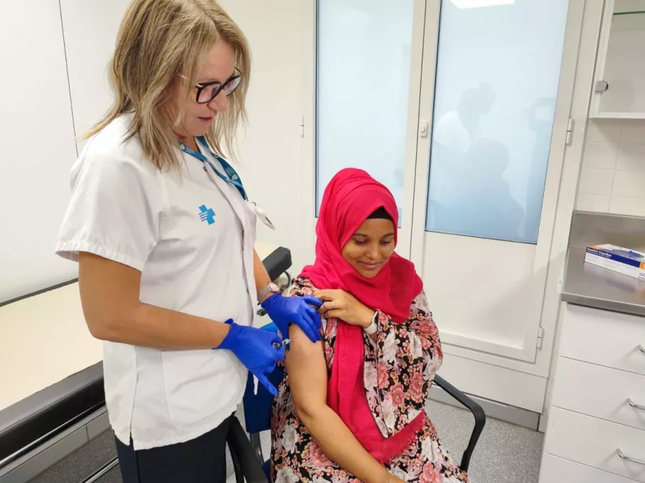 Una dona embarassada rep una dosi de vacuna coincidint amb la campanya contra la grip i la COVID-19