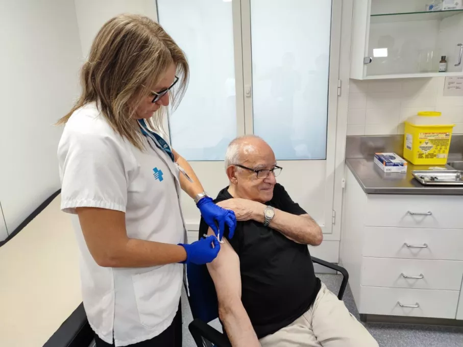 Una home rep una dosi de vacuna coincidint amb la campanya contra la grip i la COVID-19