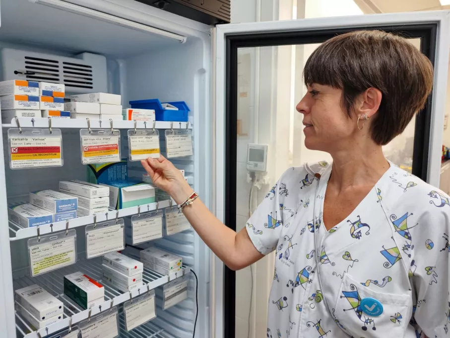 Professional de l'ICS Girona revisa les etiquetes identificatives d'una de les neveres on s'emmagatzemen les vacunes.