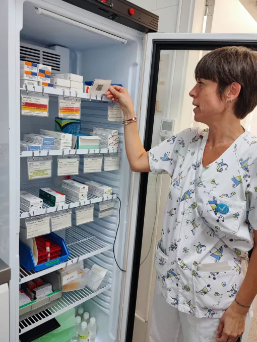 Una professional d'atenció primària de l'ICS Girona revisa les etiquetes identificatives d'una de les neveres on s'emmagatzemen les vacunes.