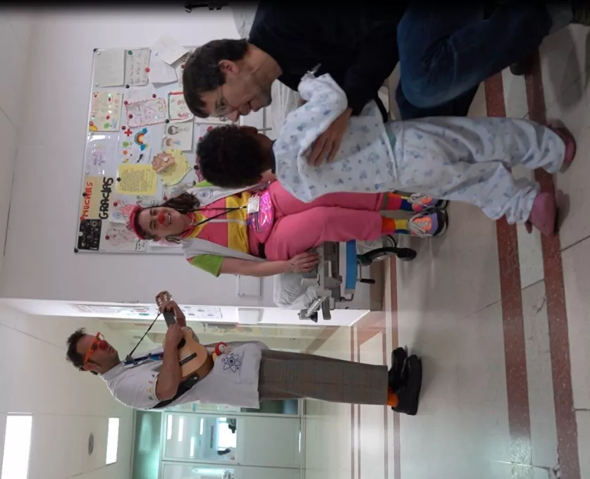 Pallassos hospitalaris de Pallapupas comparteixen activitats lúdiques amb un infant.