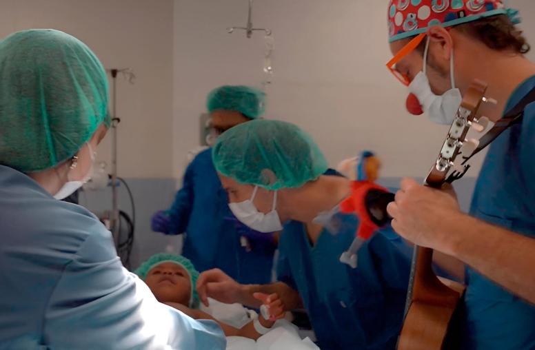 Un infant ja a quiròfan durant la inducció a l'anestèsia i acompanyat per un familiar i un component de Pallapupas. 