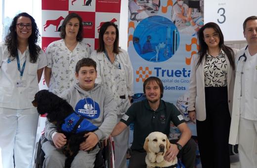 Representants de la Unitat Funcional de Paràlisi Cerebral i de Purina durant la visita a la consulta.