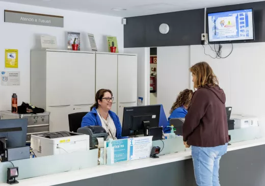 Una professional de l'equip d'atenció primària de Canet atén una usuària al taulell d'informació