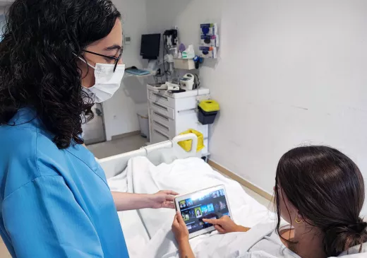 La infermera Laura Cano facilita la tauleta per realitzar l'estudi sobre l'efecte de la distracció audiovisual i musical en l'ansietat de les persones postoperades.