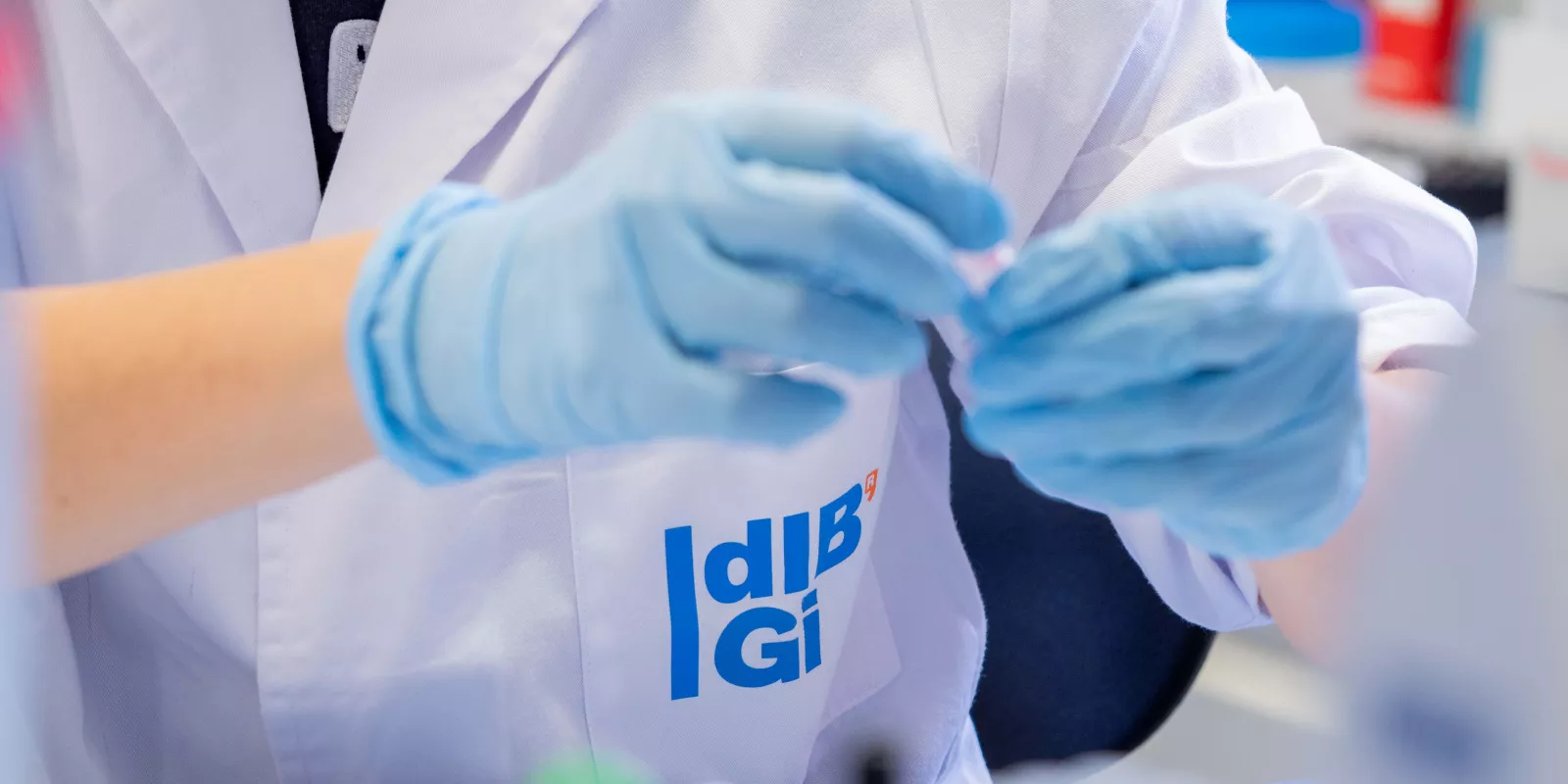 Manos con guantes manipulando una muestra