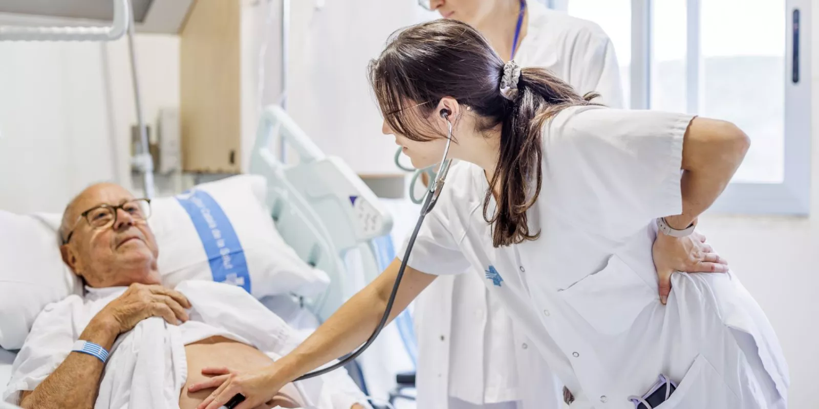 Una professional del Servei de Cirurgia General del Trueta atén una persona ingressada al centre.