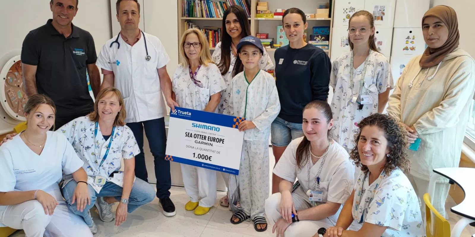 El director de Sea Otter Europe i la ciclista Txell Figueras visiten els professionals de la planta de pediatria del Trueta per fer entrega del xec solidari.