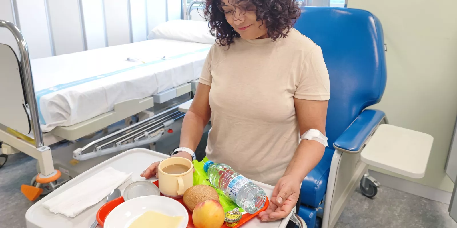 Usuària de l'Hospital de Dia del Trueta rep una safata de l'esmorzar, formada per productes saludables.