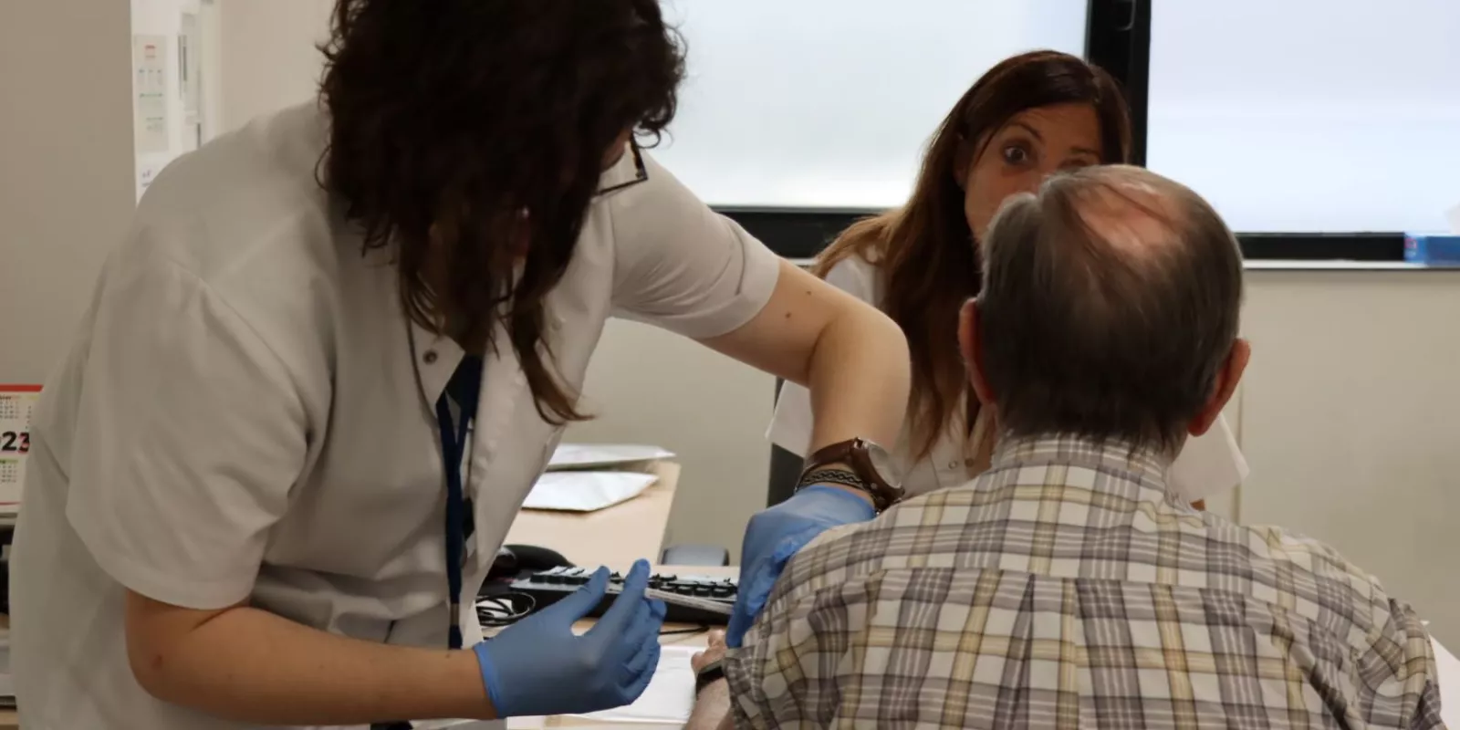 Una professional administra una vacuna durant un assaig clínic.