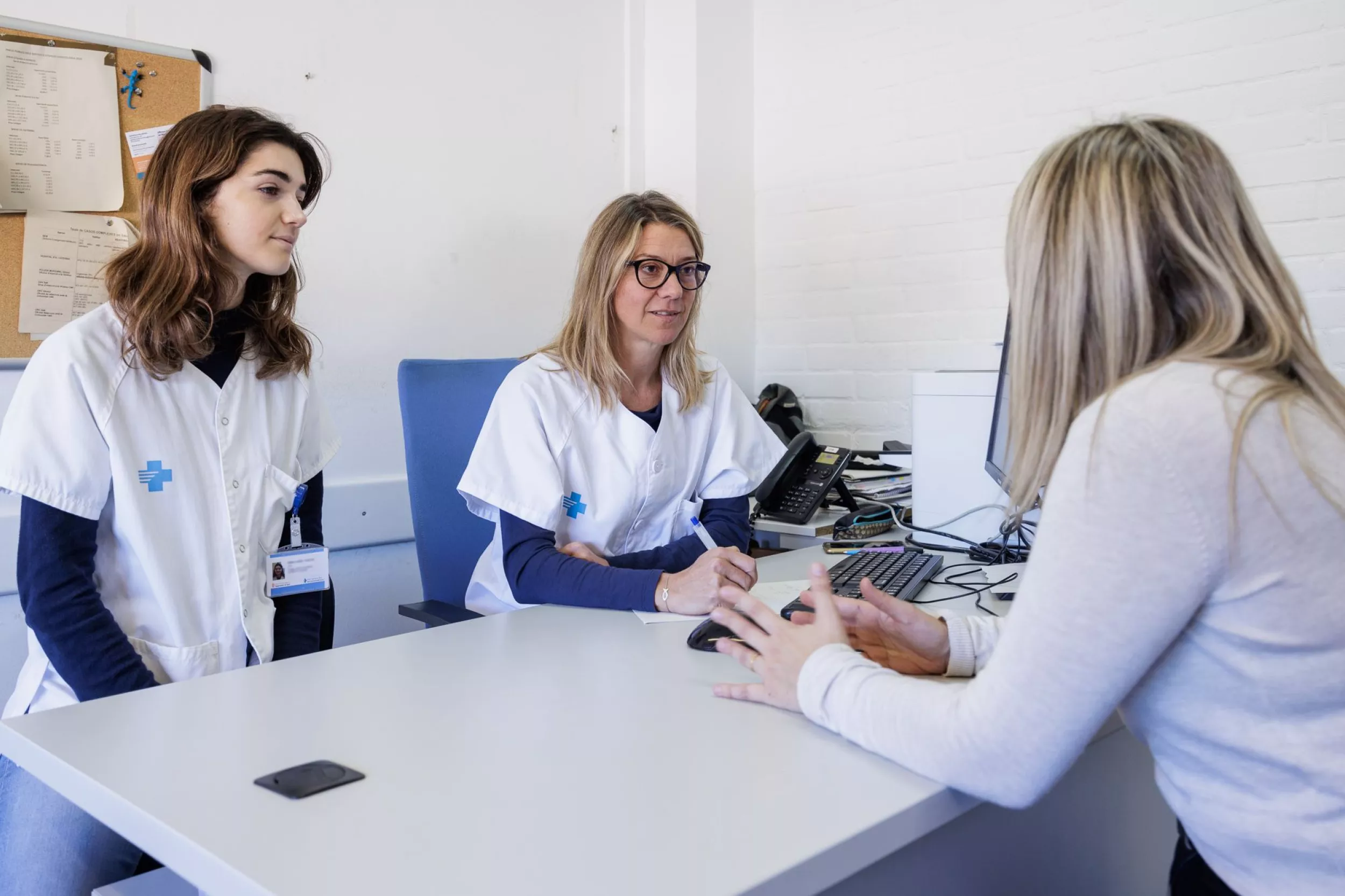 Médico y residente hablando con una paciente